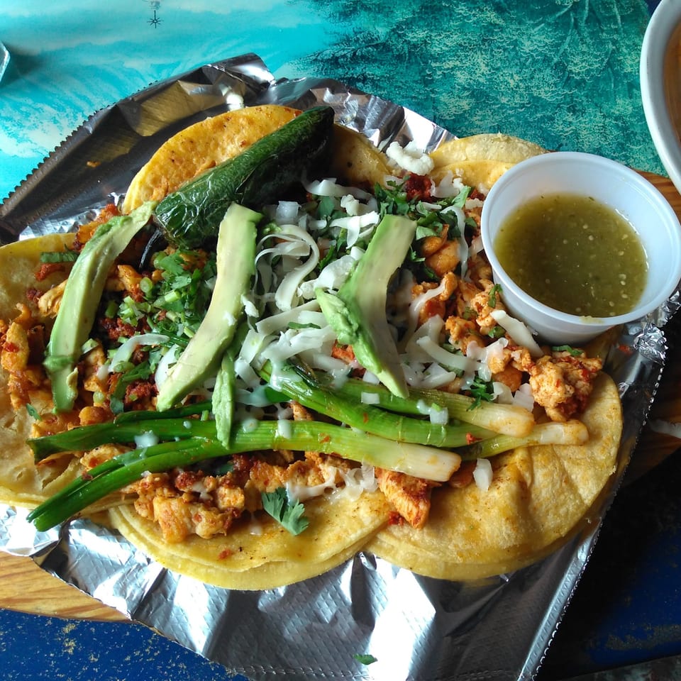 La Casona Mexican Restaurant's chicken tacos with avocado, onions, cilantro, and green salsa.